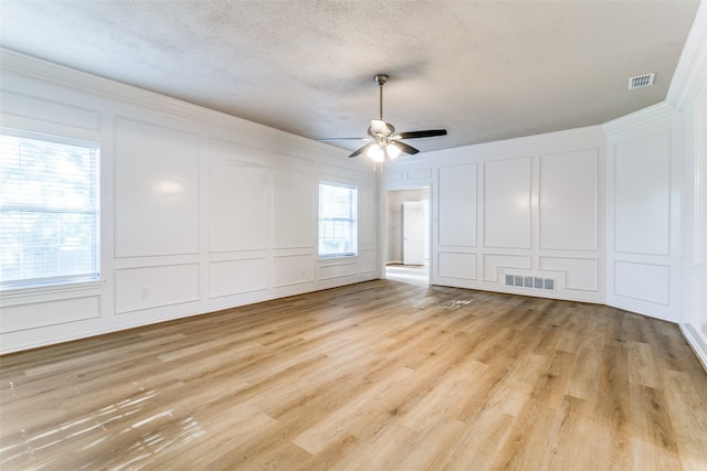 2 Linderhof Cir, Bedford, TX 76022 - empty room featuring a decorative wall, ceiling fan, light wood finished floors, a textured ceiling, and crown molding