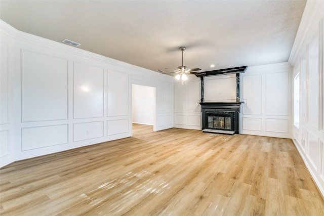 2 Linderhof Cir, Bedford, TX 76022 - unfurnished living room featuring a decorative wall, light wood finished floors, a fireplace, a ceiling fan, and crown molding