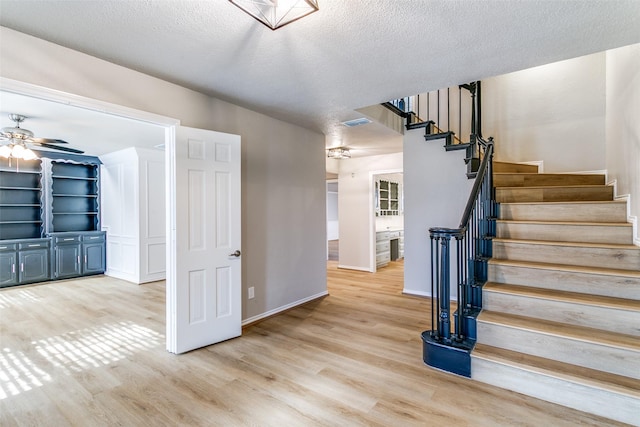 2 Linderhof Cir, Bedford, TX 76022 - staircase featuring wood finished floors, a ceiling fan, a textured ceiling, and baseboards