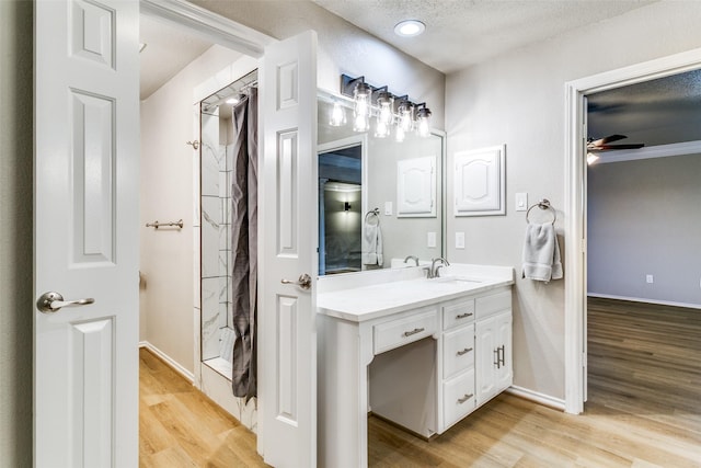 2 Linderhof Cir, Bedford, TX 76022 - bathroom with vanity, wood finished floors, a textured ceiling, baseboards, and a ceiling fan