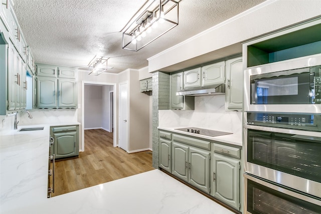2 Linderhof Cir, Bedford, TX 76022 - kitchen featuring a sink, appliances with stainless steel finishes, a textured ceiling, light wood finished floors, and under cabinet range hood