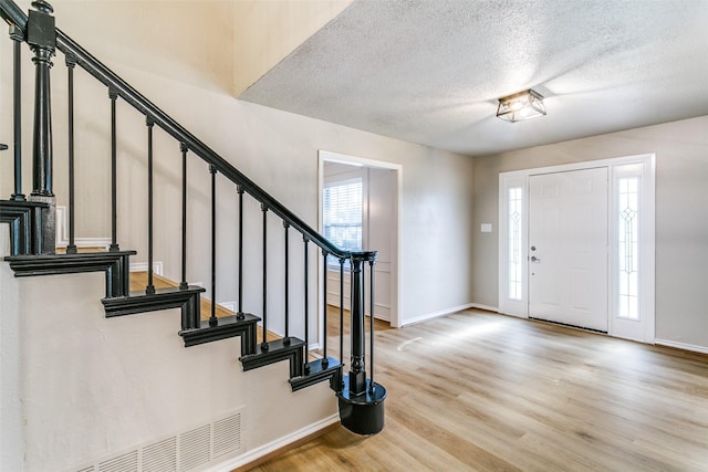 2 Linderhof Cir, Bedford, TX 76022 - entrance foyer featuring light wood-style floors, plenty of natural light, baseboards, and a textured ceiling