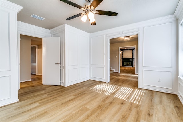 2 Linderhof Cir, Bedford, TX 76022 - spare room featuring a decorative wall, a ceiling fan, light wood-style floors, and ornamental molding