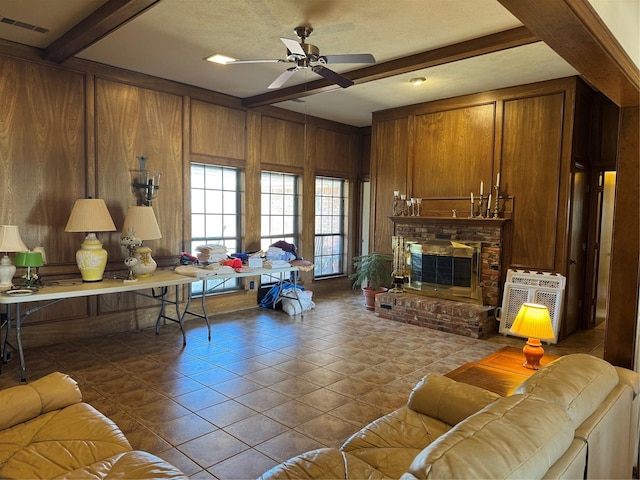 2317 Cliffside Dr, Plano, TX 75023 - tiled living room featuring beamed ceiling, wooden walls, a ceiling fan, and a fireplace