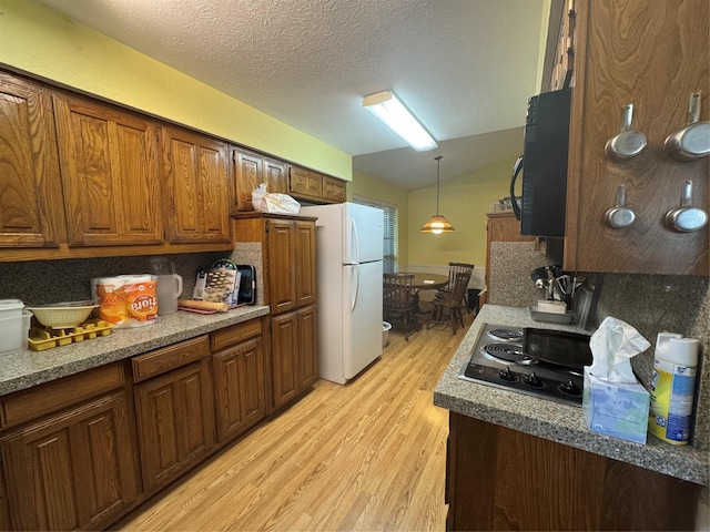 2317 Cliffside Dr, Plano, TX 75023 - kitchen with freestanding refrigerator, light wood-style flooring, stainless steel electric stovetop, hanging light fixtures, and a textured ceiling