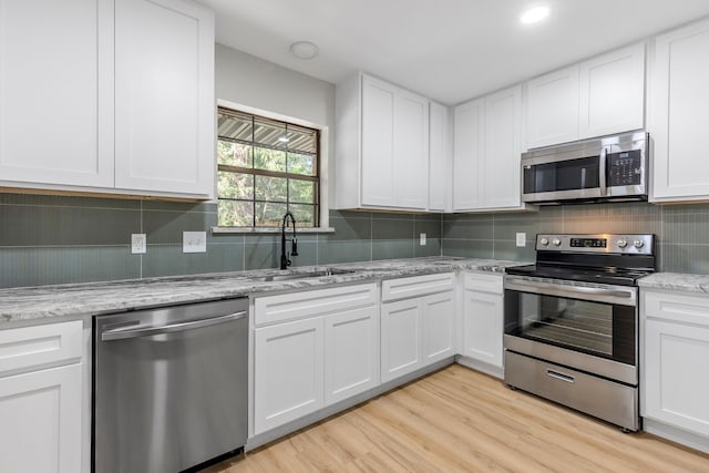 3562 Bent Oak St E, Greenville, TX 75401 - kitchen with appliances with stainless steel finishes, white cabinets, tasteful backsplash, light wood-style flooring, and light stone counters