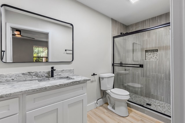 3562 Bent Oak St E, Greenville, TX 75401 - bathroom with toilet, a shower stall, vanity, wood finished floors, and baseboards