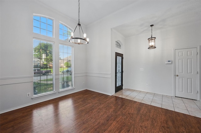 1521 Treeline Dr, Desoto, TX 75115 - unfurnished dining area featuring a chandelier, wood finished floors, a towering ceiling, and baseboards