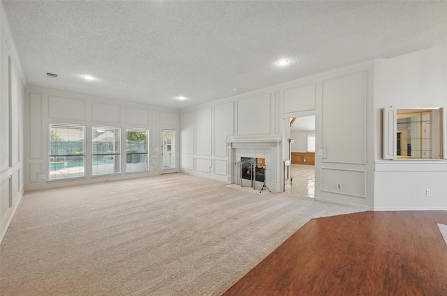 1521 Treeline Dr, Desoto, TX 75115 - unfurnished living room featuring a decorative wall, crown molding, recessed lighting, a textured ceiling, and a fireplace with flush hearth