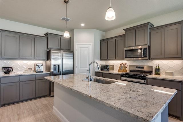 1824 Rachel St, Northlake, TX 76247 - kitchen with stainless steel appliances, a sink, tasteful backsplash, light stone countertops, and an island with sink