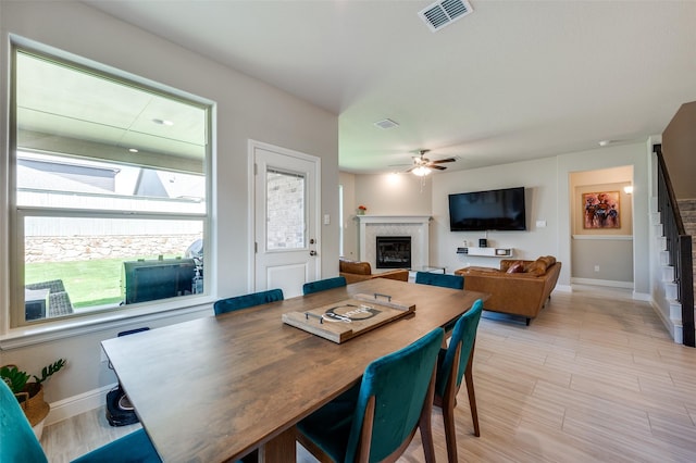 1824 Rachel St, Northlake, TX 76247 - dining area with a glass covered fireplace, baseboards, a ceiling fan, stairway, and light wood-style floors