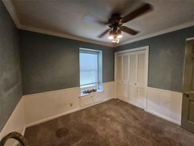 236 La Jolla Dr, Athens, TX 75751 - unfurnished bedroom featuring dark carpet, crown molding, a wainscoted wall, a closet, and ceiling fan