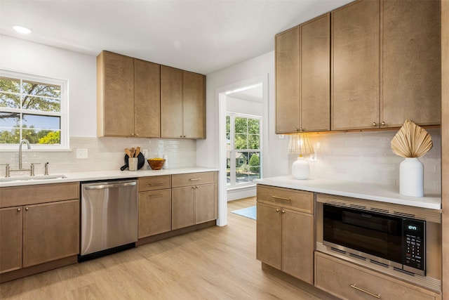 2626 Club Meadow Dr, Garland, TX 75043 - kitchen with stainless steel appliances, a sink, light wood-type flooring, and light countertops