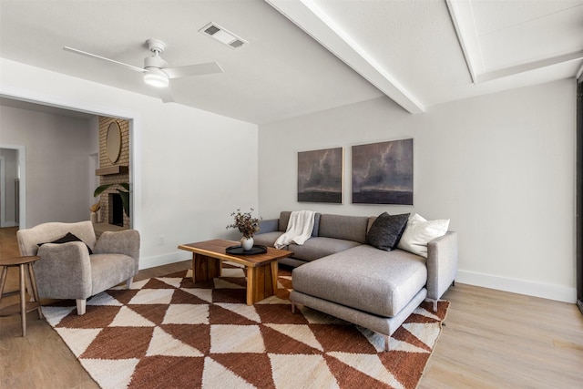 2626 Club Meadow Dr, Garland, TX 75043 - living room featuring light wood-style flooring, a brick fireplace, baseboards, a ceiling fan, and beam ceiling