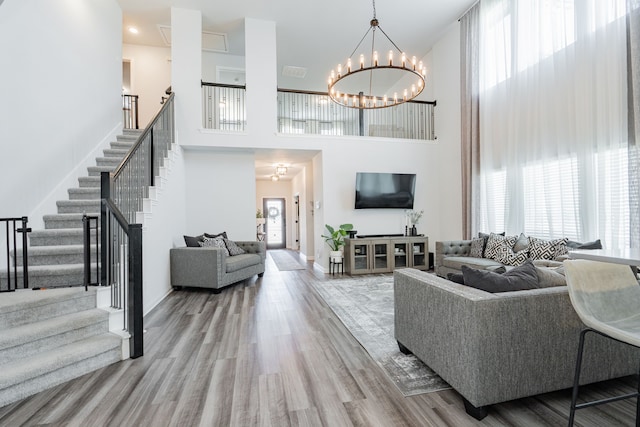 2049 Hartley Dr, Forney, TX 75126 - living area featuring a high ceiling, stairway, wood finished floors, a chandelier, and baseboards