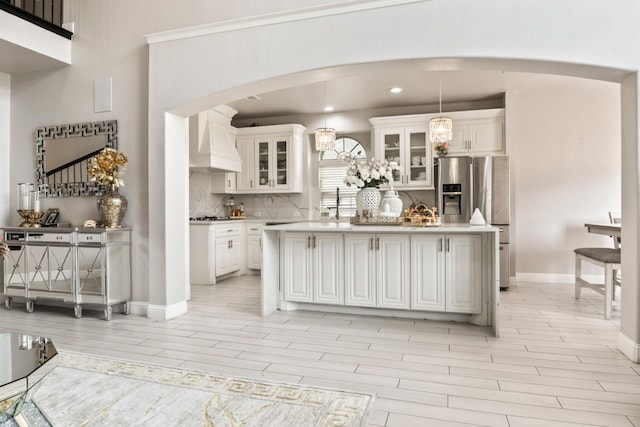 14237 Sugar Hill Dr, Little Elm, TX 75068 - kitchen with custom range hood, arched walkways, light wood-type flooring, light countertops, and recessed lighting