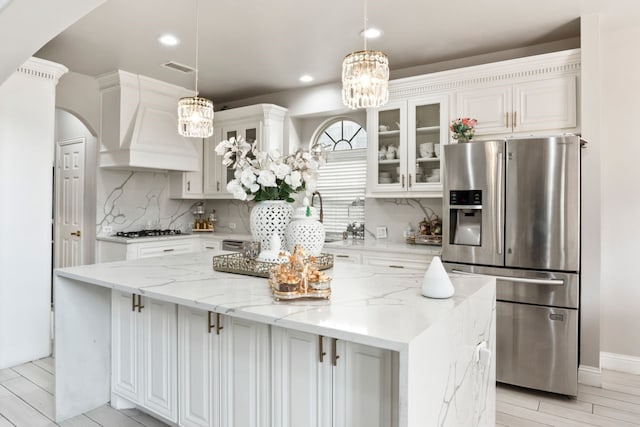 14237 Sugar Hill Dr, Little Elm, TX 75068 - kitchen with stainless steel fridge, a chandelier, decorative backsplash, white cabinetry, and recessed lighting