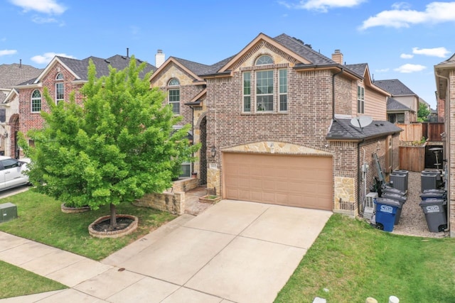 14237 Sugar Hill Dr, Little Elm, TX 75068 - traditional-style house featuring a chimney, an attached garage, driveway, brick siding, and stone siding