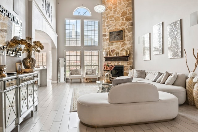 14237 Sugar Hill Dr, Little Elm, TX 75068 - living room with a high ceiling, a fireplace, arched walkways, and wood finished floors