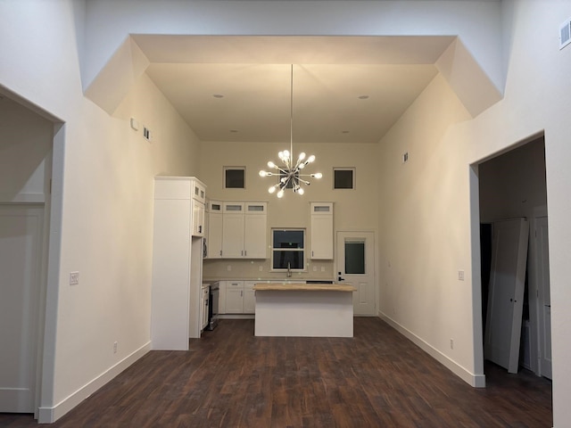 5518 Cold Water Trl, Granbury, TX 76048 - kitchen with a towering ceiling, white cabinetry, a chandelier, baseboards, and a kitchen island