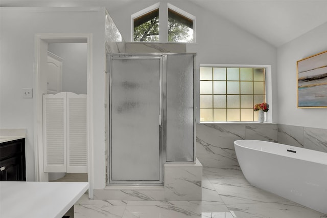 4909 Berkeley Ct, Garland, TX 75043 - full bathroom with a shower stall, vaulted ceiling, marble finish flooring, a freestanding bath, and a wainscoted wall