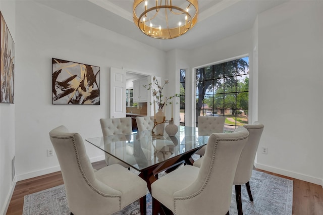 4909 Berkeley Ct, Garland, TX 75043 - dining space featuring a chandelier, wood finished floors, and baseboards