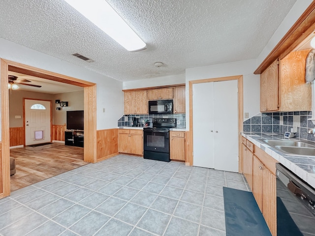 462 Anderson Ln, Fairfield, TX 75840 - kitchen featuring black appliances, a sink, wainscoting, light countertops, and a textured ceiling