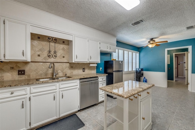 6400 Kingswood Dr, Fort Worth, TX 76133 - kitchen with appliances with stainless steel finishes, a sink, a ceiling fan, white cabinetry, and a textured ceiling