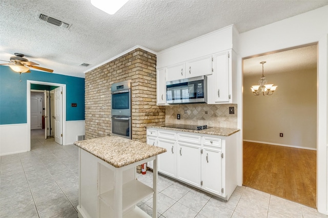 6400 Kingswood Dr, Fort Worth, TX 76133 - kitchen with appliances with stainless steel finishes, white cabinets, a ceiling fan, light tile patterned floors, and a chandelier