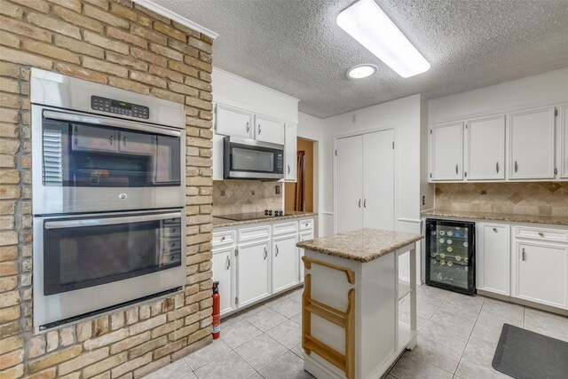 6400 Kingswood Dr, Fort Worth, TX 76133 - kitchen with wine cooler, stainless steel appliances, light tile patterned floors, a textured ceiling, and backsplash