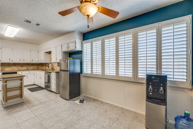 6400 Kingswood Dr, Fort Worth, TX 76133 - kitchen with appliances with stainless steel finishes, a sink, a textured ceiling, a ceiling fan, and light tile patterned flooring