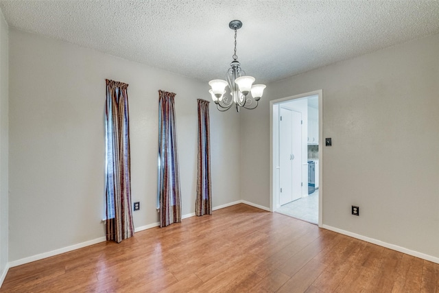 6400 Kingswood Dr, Fort Worth, TX 76133 - empty room featuring a chandelier, light wood-type flooring, baseboards, and a textured ceiling