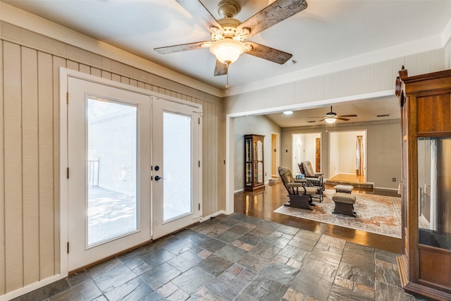 6400 Kingswood Dr, Fort Worth, TX 76133 - entryway featuring french doors, stone tile flooring, ceiling fan, baseboards, and wood walls
