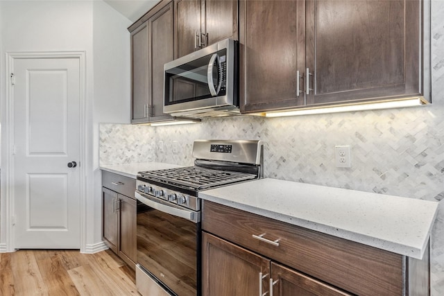 101 Lisa Ln, Royse City, TX 75189 - kitchen featuring stainless steel appliances, decorative backsplash, light wood finished floors, and light stone counters