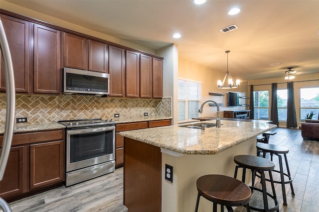 4825 Lazy Oaks St, Fort Worth, TX 76244 - kitchen featuring appliances with stainless steel finishes, a sink, tasteful backsplash, light stone counters, and a chandelier