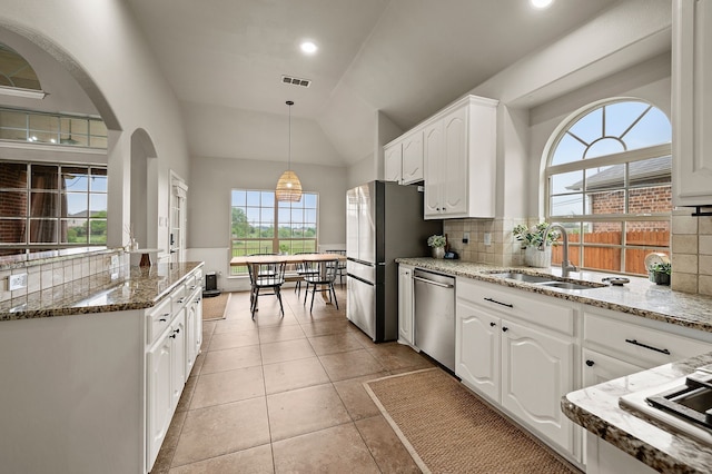 11404 Grapeleaf Dr, Fort Worth, TX 76244 - kitchen featuring appliances with stainless steel finishes, a sink, stone counters, white cabinets, and arched walkways