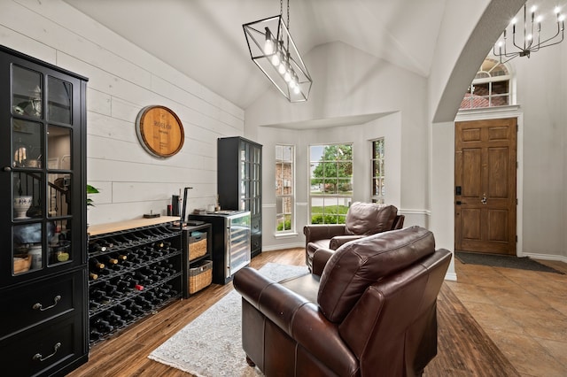 11404 Grapeleaf Dr, Fort Worth, TX 76244 - living area featuring wooden walls, a dry bar, high vaulted ceiling, and wood finished floors