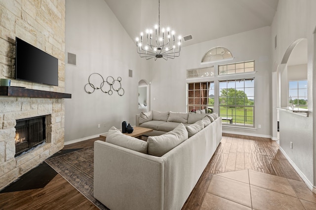 11404 Grapeleaf Dr, Fort Worth, TX 76244 - living area featuring high vaulted ceiling, arched walkways, dark wood-style floors, a fireplace, and a chandelier
