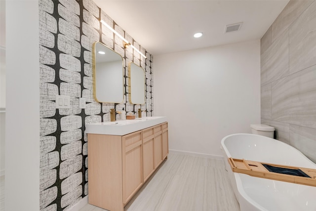 1720 Meadow Valley Ln, Dallas, TX 75232 - full bathroom featuring double vanity, a freestanding bath, recessed lighting, and baseboards
