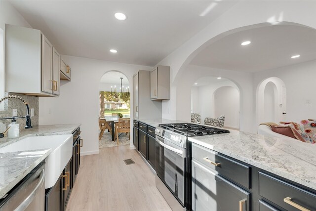 1720 Meadow Valley Ln, Dallas, TX 75232 - kitchen featuring stainless steel appliances, a sink, light wood-style floors, light stone countertops, and recessed lighting