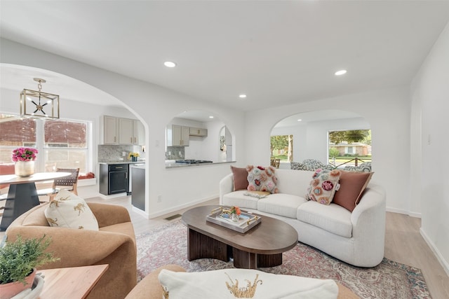 1720 Meadow Valley Ln, Dallas, TX 75232 - living room featuring light wood-type flooring, recessed lighting, arched walkways, and baseboards