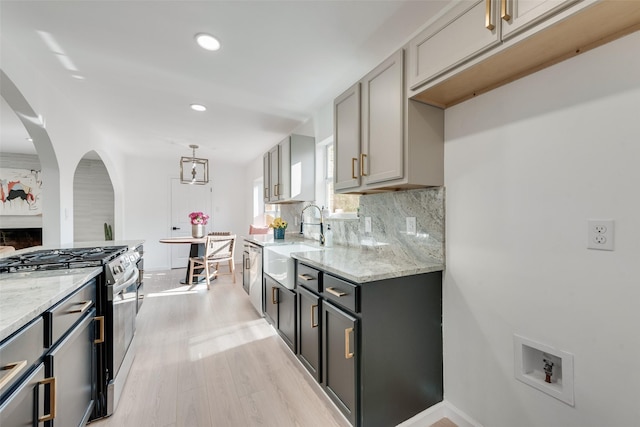 1720 Meadow Valley Ln, Dallas, TX 75232 - kitchen with stainless steel appliances, a sink, light stone counters, tasteful backsplash, and recessed lighting