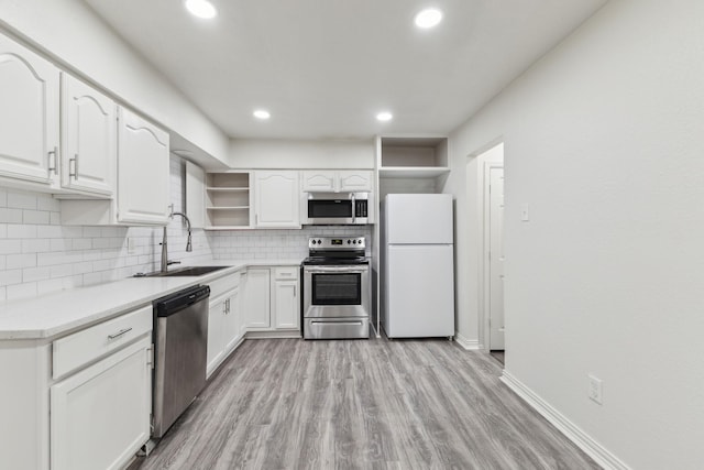 3527 Palm Dr, Mesquite, TX 75150 - kitchen featuring appliances with stainless steel finishes, open shelves, tasteful backsplash, a sink, and white cabinetry