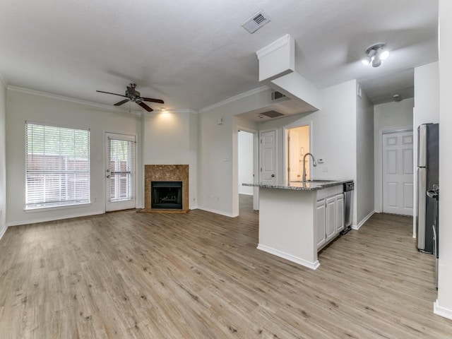 7151 Gaston Ave Unit 906, Dallas, TX 75214 - kitchen with a sink, ceiling fan, light stone countertops, stainless steel appliances, and a peninsula