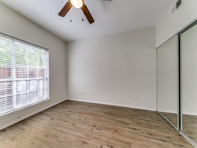 7151 Gaston Ave Unit 906, Dallas, TX 75214 - unfurnished bedroom featuring a closet, wood finished floors, baseboards, and a ceiling fan