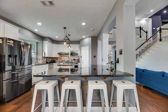 1529 Arrowhead Ln, Carrollton, TX 75007 - kitchen with stainless steel appliances, a sink, dark wood-style floors, white cabinets, and recessed lighting