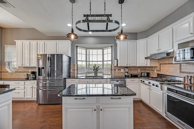 1529 Arrowhead Ln, Carrollton, TX 75007 - kitchen with stainless steel appliances, decorative backsplash, a center island, a sink, and white cabinetry