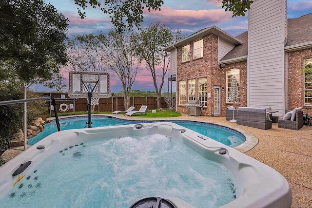 1529 Arrowhead Ln, Carrollton, TX 75007 - pool at dusk featuring a hot tub, an outdoor hangout area, and a patio