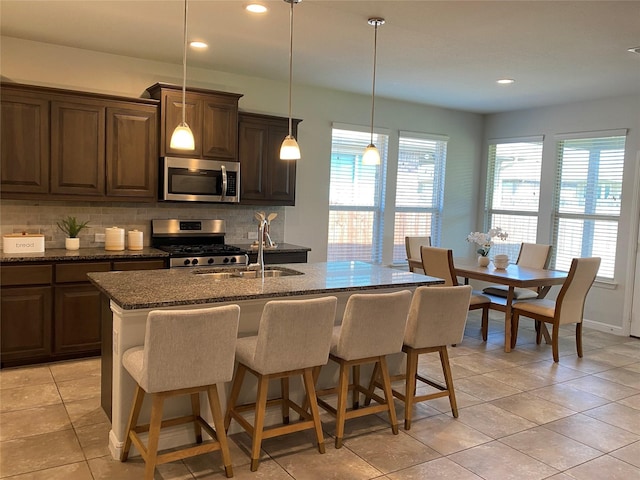 1037 Madelia Ave, Fort Worth, TX 76177 - kitchen with stainless steel appliances, tasteful backsplash, a sink, dark stone countertops, and recessed lighting