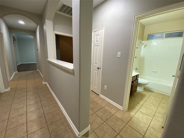 1705 Spanish Moss Way, Savannah, TX 76227 - hallway with light tile patterned flooring and arched walkways
